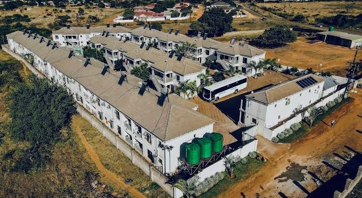 Aerial view of Muthathe Student Village grounds with shuttle bus and water storage tanks