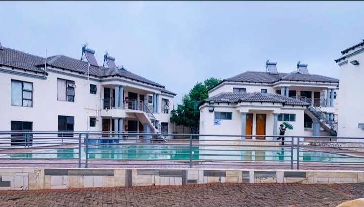 Swimming pool area at Muthathe Student Village with residence blocks in the background